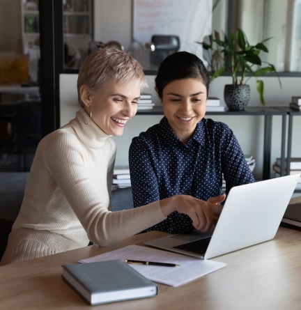 Colleagues working alongside each other on a laptop computer