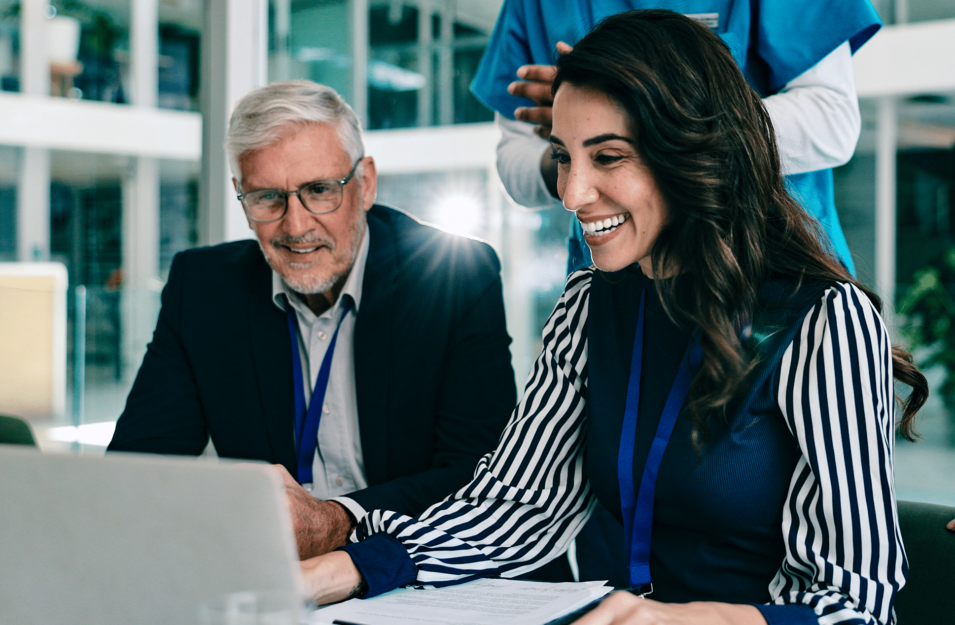 Two healthcare professionals looking at a laptop in a modern office setting.
