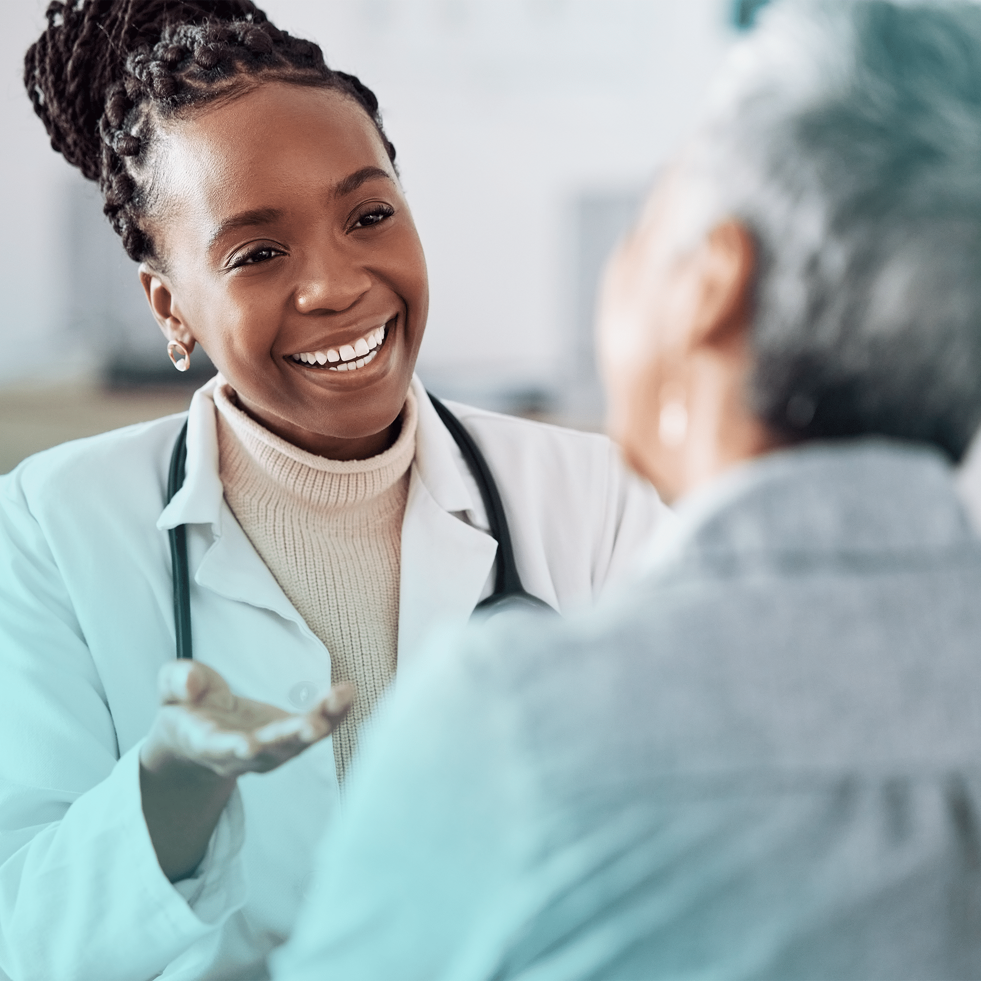 Smiling Black woman doctor speaking with an older patient in a doctors office