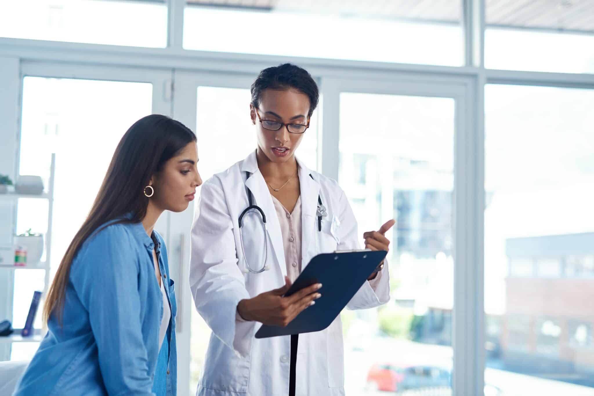 Doctor and assistant discussing chart on tablet in healthcare facility